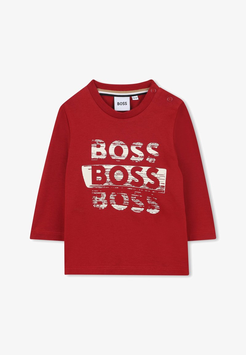 Sarkans garais piedurknes krekls, izgatavots no kokvilnas, ar teksturētu baltu grafiku, kas attēlo vārdu "BOSS" dažādās lielumos uz priekšpuses. Apaļa kakla izgriezums ar pogām.