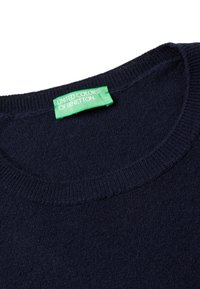Granatowy sweter z dzianiny z okrągłym dekoltem, z zieloną metką z napisem "United Colors of Benetton" wszytą od wewnątrz.