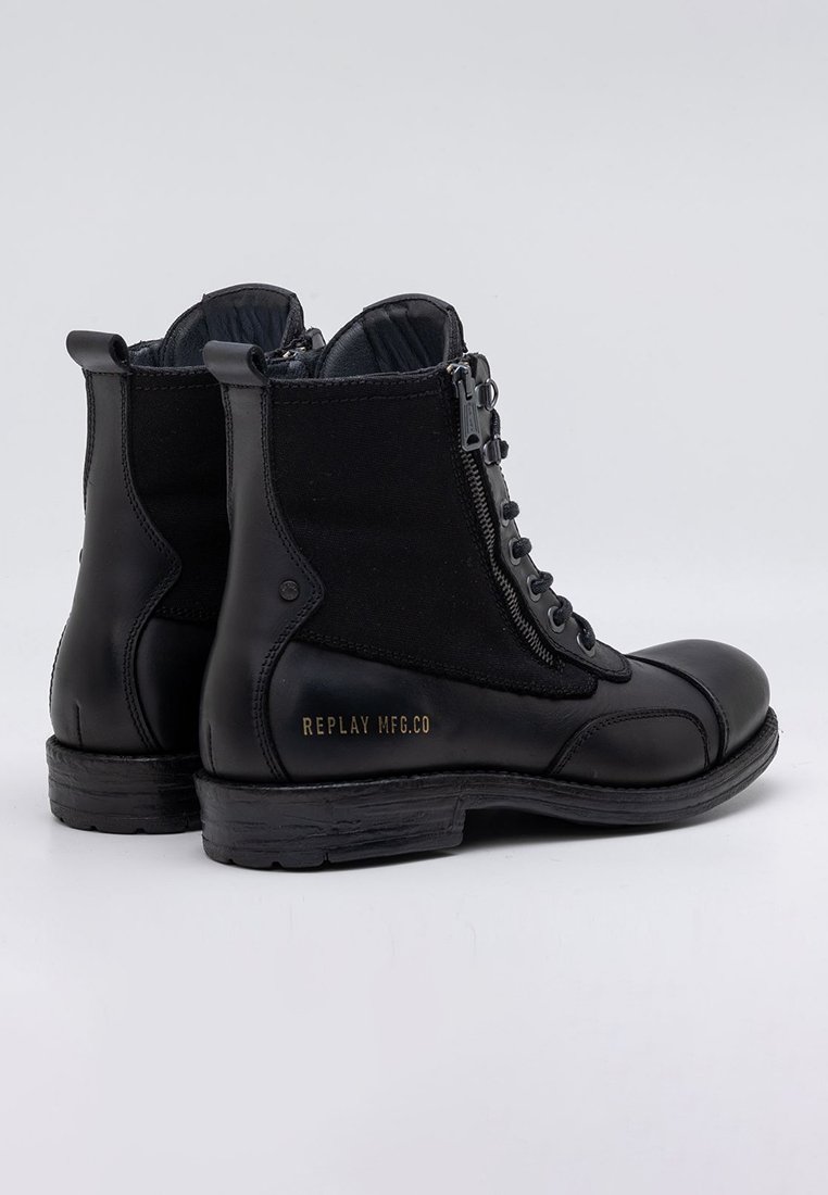 Schwarze Leder-Stiefeletten mit einer Kombination aus Stoff. Sie verfügen über einen Reißverschluss an der Seite, Schnürsenkel und ein geprägtes Logo-Detail an der Ferse. Strukturierte Oberseite.