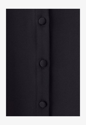 Must mustriga mustriga vertikaalne rida kuuest ringikujulisest nöörist. Nöörid on matt ja joondatud kangas õmblusega.