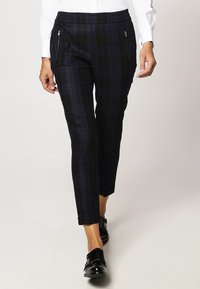 Spodnie w czarną i granatową kratę o dopasowanym fasonie, z bocznymi kieszeniami na zamek i miękkim, teksturowanym materiałem. Krótkie nogawki.