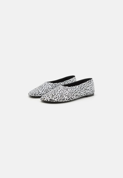 Chaussures plates avec un motif géométrique texturé en noir et blanc, fabriquées en matériau flexible, dotées d'un bout arrondi et d'un design simple.