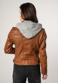 Bruine leren jas met een grijze capuchon, voorzien van gestructureerd materiaal, slim-fit ontwerp en zichtbare stiksels op de achterkant.