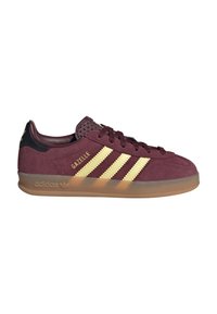 Mørkerød Adidas Gazelle sneaker med beige tre striber, gummisål, sort hælstrop og "Gazelle" tekst i guld på siden.
