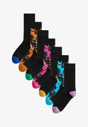 Six pairs of black crew socks with colorful toes and monster face patterns in blue, orange, pink, and purple accents.