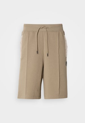 Beige bomuldsshorts med elastisk talje og snor. Har quiltede sidelommer og et logo-patch på forsiden.