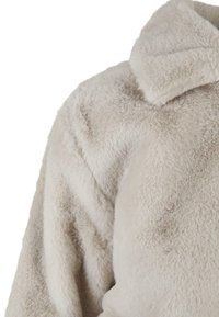 Lyse beige faux fur jakke med en blød, tekstureret overflade. Har krave med klipper og brede ærmer. Luksuriøst materiale.