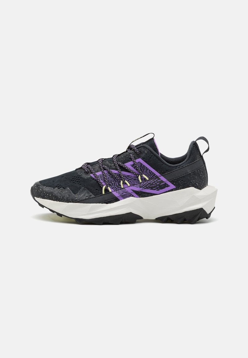Schwarzer Sportschuh mit lila Akzenten, strukturiertem Obermaterial, Zuglasche und konturiertem weißen Zwischensohlenteil. Verfügt über eine robuste schwarze Gummisohle mit Grip.