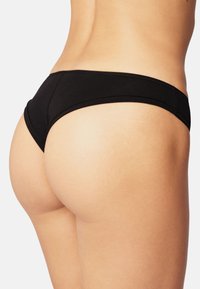 Black bikini bottom with a smooth texture, featuring a low-rise cut and minimal coverage, accentuating the body's natural shape.