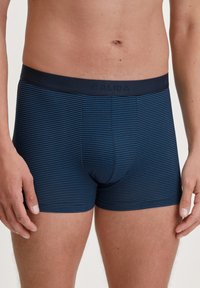 Boxer da uomo a righe blu navy con un morbido elastico etichettato "CALIDA", caratterizzati da una vestibilità aderente e una tasca sagomata per il supporto.