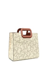 Bolsa tote con una superficie texturizada en crema que presenta patrones ondulados en relieve, complementada por un asa rectangular marrón.
