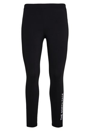 Leggings neri in tessuto elastico, caratterizzati da un design aderente. Il nome del marchio "THE NORTH FACE" è stampato in bianco lungo la gamba sinistra.