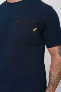 Mornarice plava majica od pamuka s džepom na prsima i crnim patentnim zatvaračem. Žuti ptičji logo s lijeve strane, kratki rukavi.