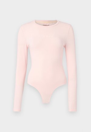 Bodysuit dugih rukava od mekanog ružičastog materijala, s logotipom "GUESS JEANS" u bijeloj boji, prilagođenog kroja i gaćicama u obliku tanga.