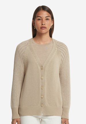 Beige stickad cardigan med djup V-ringning, femknapps stängning och vävda ärmar i texturerad spets. Mjuk textur och ribbade muddar.