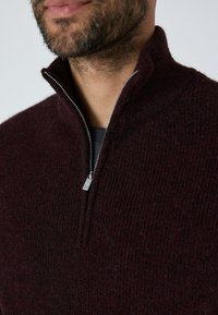 Burgunderfarbener Strickpullover mit hohem Kragen und einem halben Reißverschluss. Verfügt über einen strukturierten Stoff und ein metallisches Reißverschluss-Ziehband.