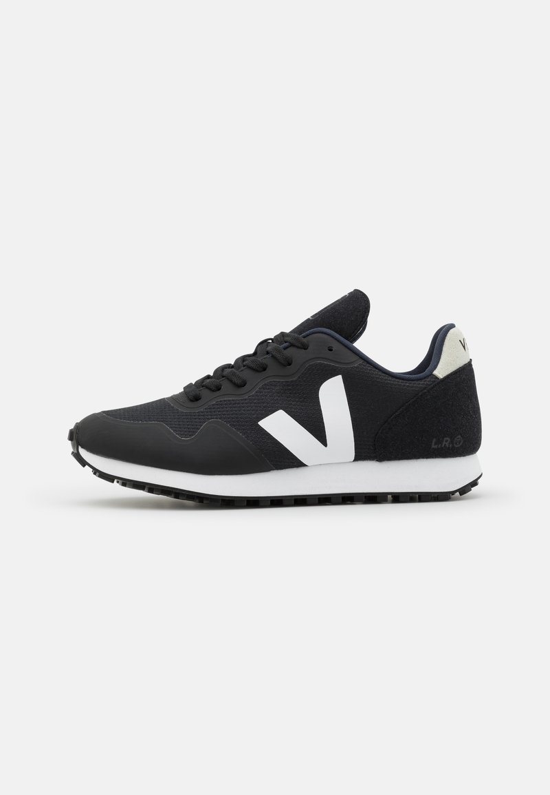 Black athletic shoe with a white V logo, textured fabric upper, padded collar, and rubber sole. Features a low profile and lace-up design.