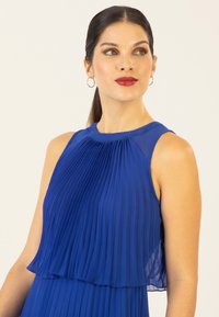 Blaues plissiertes Kleid mit transparentem Schichtdesign, ärmellosem Schnitt, rundem Ausschnitt und glatter Textur mit dezentem Glanz.