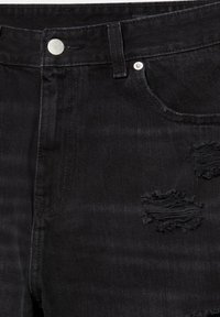 Jean en denim noir avec poches avant, bouton argenté et rivets, et deux déchirures usées sur le haut de la cuisse.