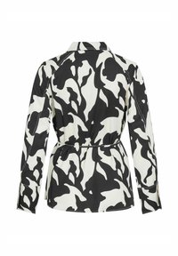 Chaqueta de camisa con patrón en blanco y negro, con cuello, mangas largas y cintura ceñida. Presenta una textura suave y costuras en contraste.