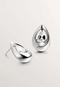 Pendientes en forma de lágrima de plata que cuentan con acentos de cristal transparente dentro de un marco de metal pulido, mostrando curvas suaves y un acabado brillante.