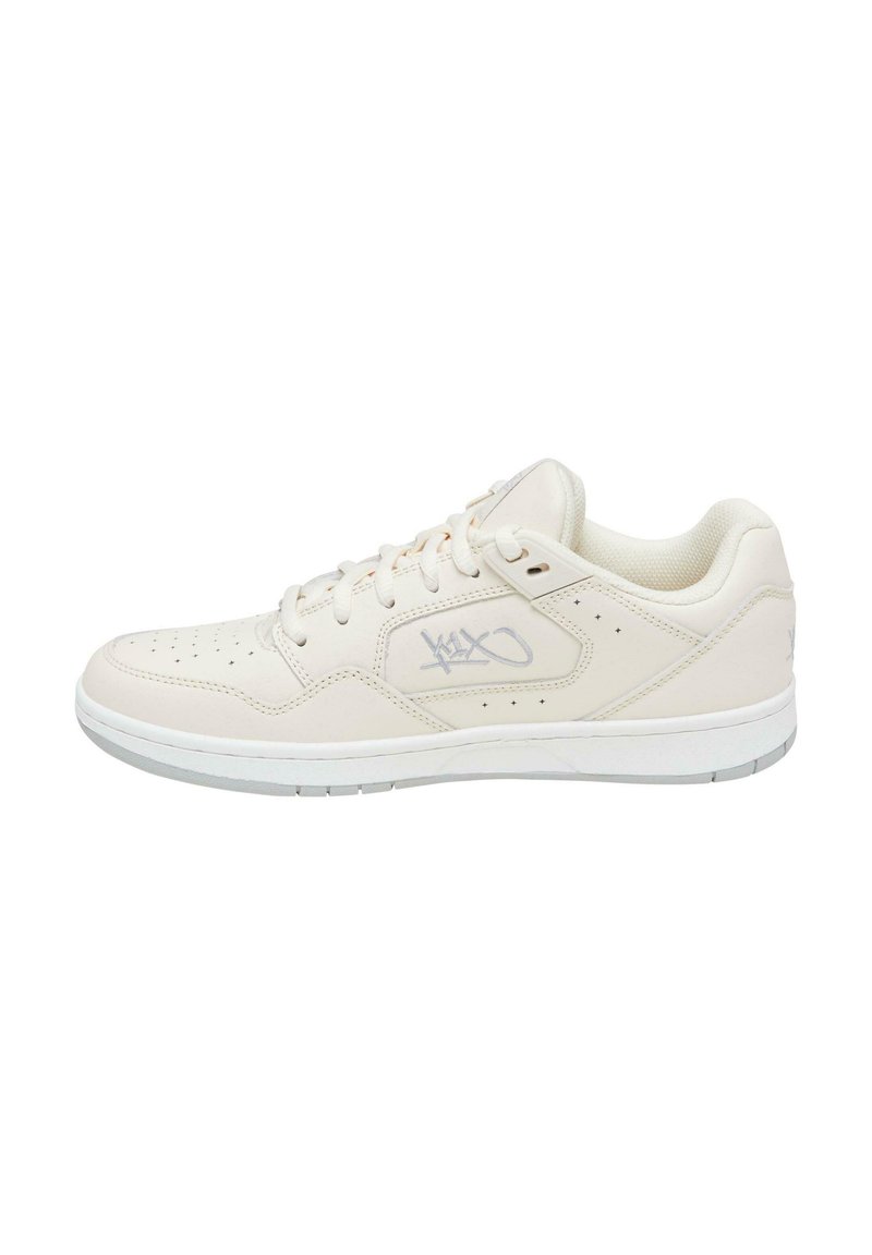 Hvite lær sneakers med perforeringer, teksturert tåhette, tonale sømmer og en subtil logo på siden. Gummisåle med lett grep mønster.