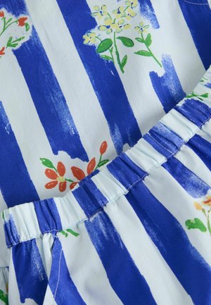 Modrobíle pruhovaná látka s malými oranžovožlutými květinovými vzory a nařaseným elastickým pasem.