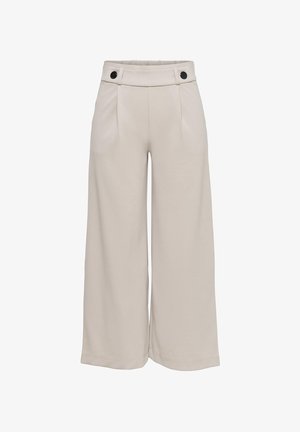 Pantalon beige à jambes larges avec taille haute, plis au devant et boutons noirs en accent sur la ceinture.