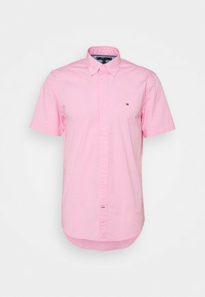 Světle růžová krátká košile s krátkým rukávem, zapínáním na knoflíky, límcem se zapínáním na knoflíky a malým vyšívaným logem na levé kapse.