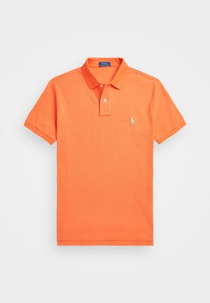 Polo shirt orange en coton, avec un col, une patte de boutonnage à deux boutons et un petit logo brodé sur la poitrine gauche.