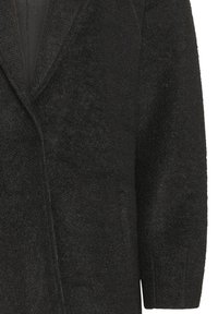 Cappotto nero in tessuto testurizzato con scollatura a V profonda, maniche lunghe e senza chiusure. Il tessuto sembra spesso e accogliente, adatto per il clima freddo.