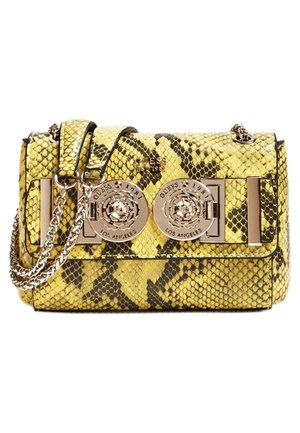 Żółta i czarna torebka ze wzorem skóry węża, z łańcuszkowym paskiem i dwoma dużymi okrągłymi złotymi zapięciami z logo Guess na przedniej części.