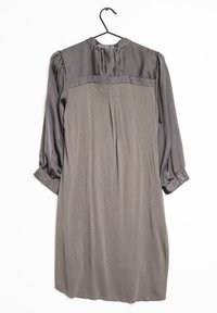 Robe grise à manches longues avec un dos supérieur brillant et des poignets, accrochée à un cintre noir sur fond blanc.