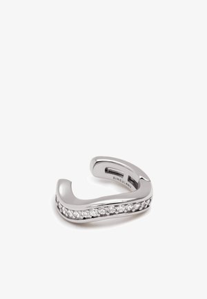 Silberfarbener Ring mit einem glatten, geschwungenen Design und einer Reihe von eingearbeiteten klaren Edelsteinen auf einer Seite. Polierte Metalloberfläche, offene Form.