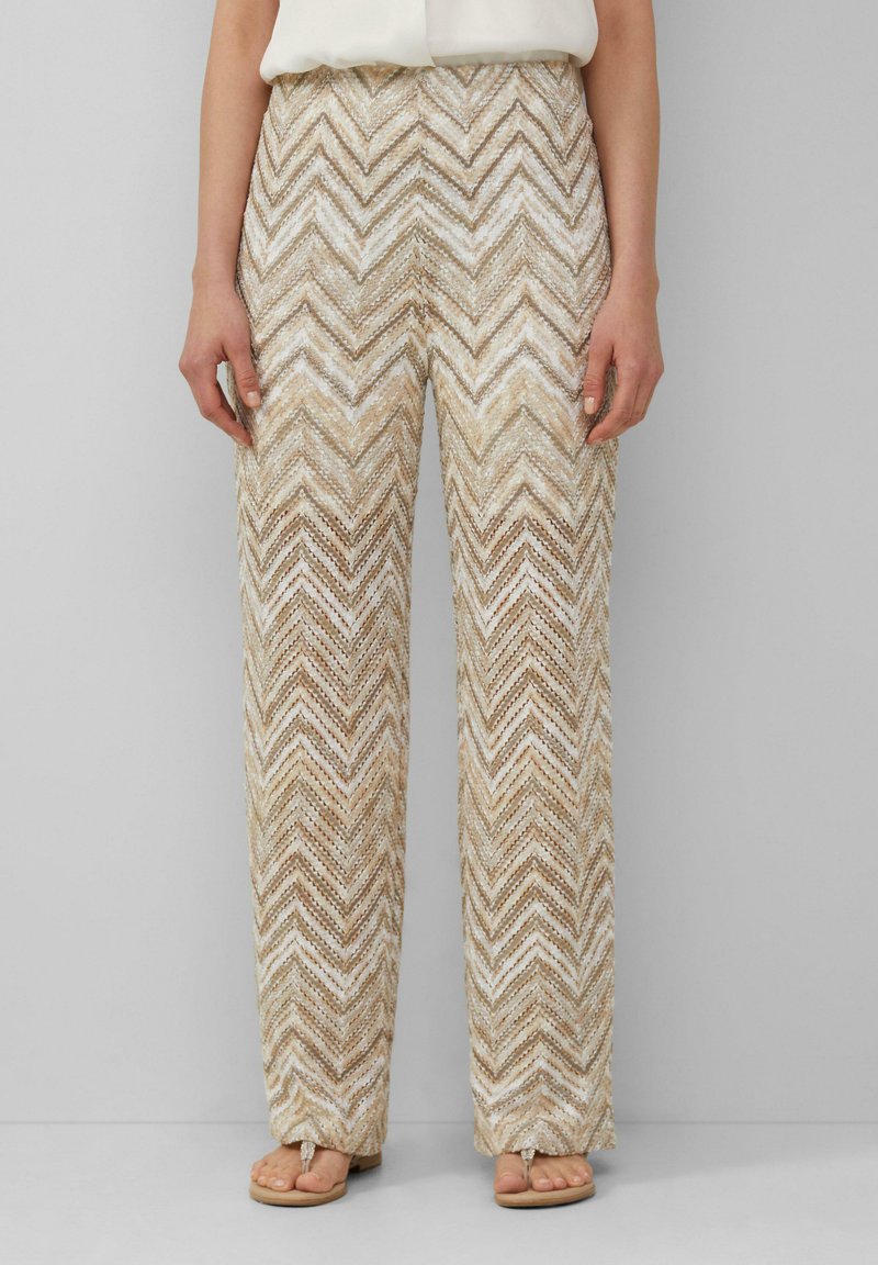 Beige wijde broek met een zigzagpatroon in crèmekleurige en bruine tinten, gemaakt van textuurstof met een relaxte pasvorm.