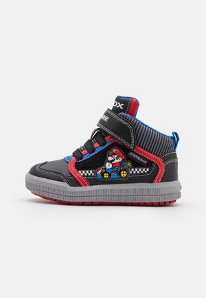 Zapatilla alta para niños en colores negro, rojo, azul y gris, con un gráfico de un personaje de Mario Kart en el lateral y cierre de velcro.