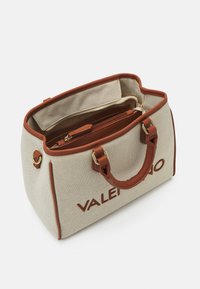 Borsa a tracolla in tela beige con dettagli in pelle marrone, accessori in oro e zip superiore. Presenta manici doppi e un logo sulla parte frontale.