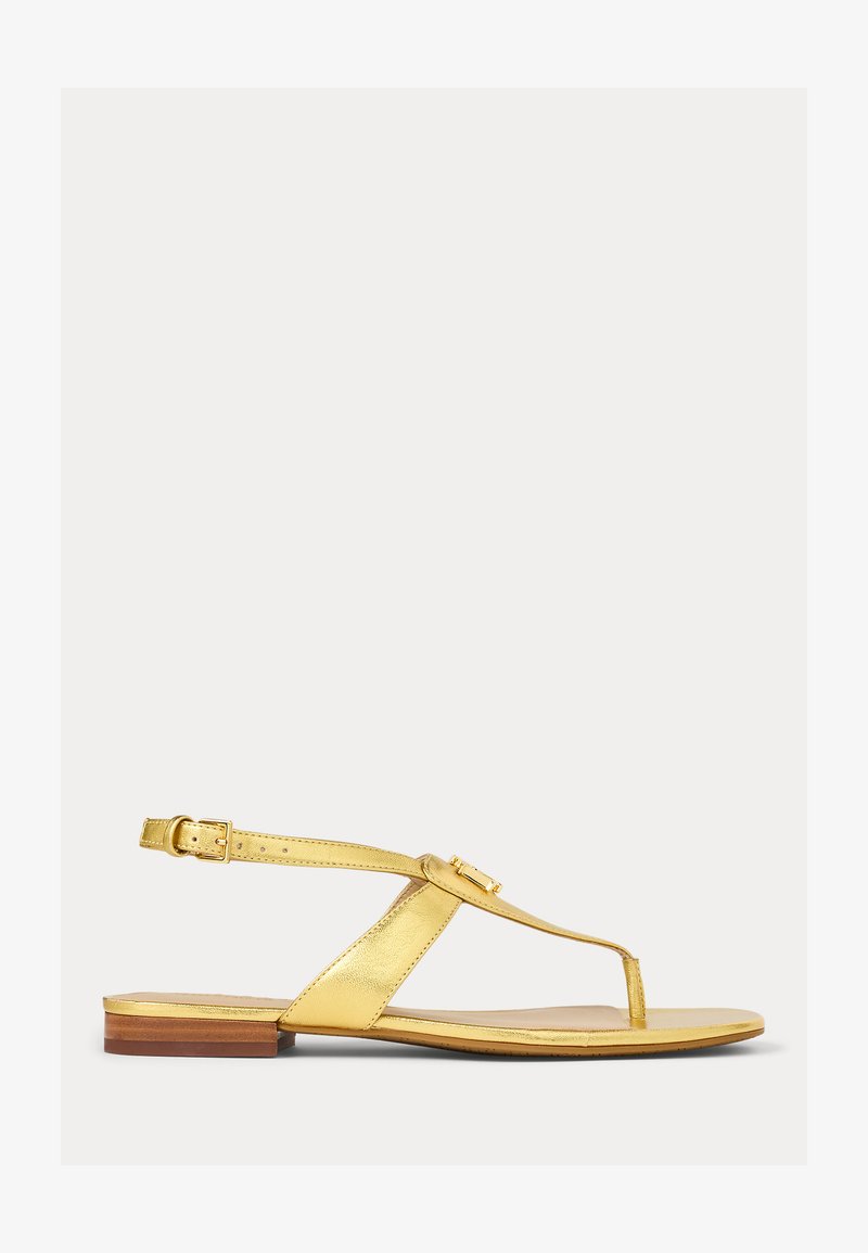 Χρυσά μεταλλικά επίπεδα σανδάλια με σχέδιο δαχτυλίδι, λουράκι στον αστράγαλο και λεπτομέρεια από αγκράφα; μινιμαλιστικό στυλ με ξύλινη μπλοκ σόλα.