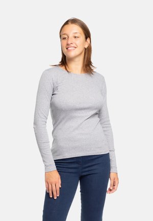 Maglietta grigia a maniche lunghe aderente realizzata in morbido cotone. Caratterizzata da un colletto a girocollo e da una texture liscia, abbinata a jeans scuri.