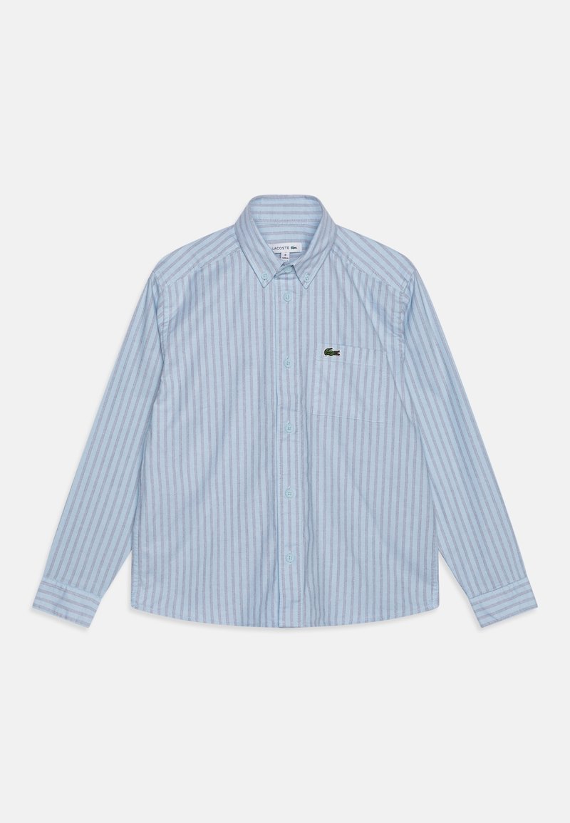 Chemise à manches longues bleu clair à boutons, avec des rayures verticales blanches et bleues, et un petit logo de crocodile vert sur la poche poitrine gauche.