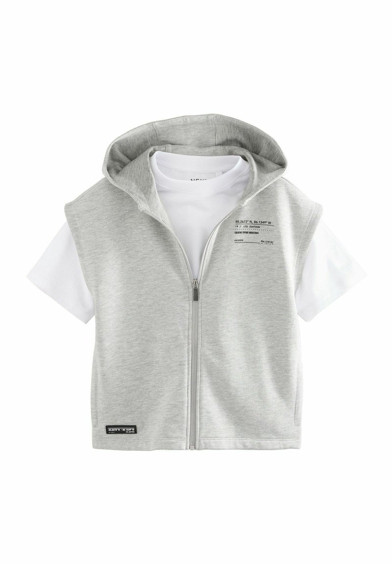 Lys grå hættevest med lynlås over en hvid t-shirt. Har et trykt mærke på vesten og en sort accentmærke forneden.
