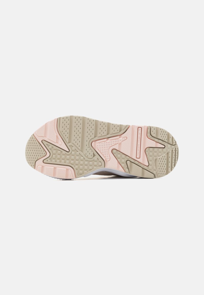 Schuhsohle mit einem beigen Gummibasis, pinken Akzenten und strukturierten Mustern für besseren Halt. Die Form ist athletisch und verfügt über ein gewölbtes Design sowie vielfältige Texturen.