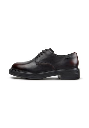 Chaussure habillée en cuir noir à lacets avec semelle épaisse et petit talon, vue de côté sur fond blanc.