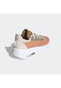 Footwear featuring a pink and beige fabric upper, with a white rubber sole and stitched accents. Includes logo detail on the side.