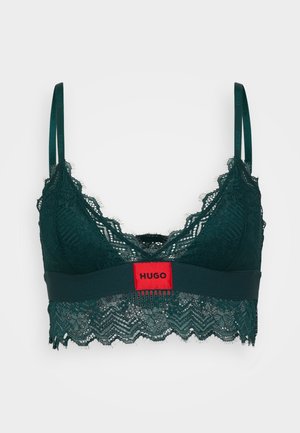 Grüner Spitzen-Bralette mit gewelltem Design, ausgestattet mit einem roten Logetik. Strukturierte Spitze und ein solider Bund erzeugen einen Kontrast. Verstellbare Träger.