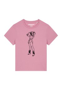 T-shirt en coton rose avec une illustration en ligne noire d'une figure portant un chapeau et des bottes, à manches courtes et décolleté rond.