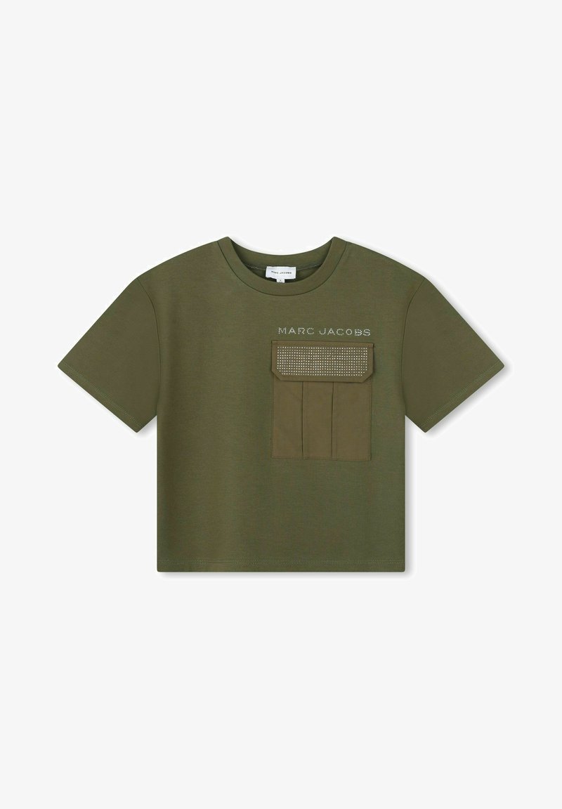 T-shirt verde oliva con maniche corte, dotata di una tasca sul petto e la scritta "MARC JACOBS" sopra in un colore a contrasto. Texture liscia.