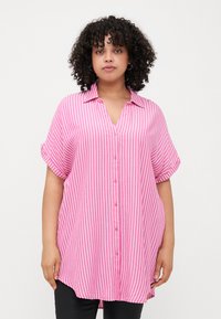 Pink and white striped button-up shirt with a collar, short rolled sleeves, a relaxed fit, and a slightly longer back hem.