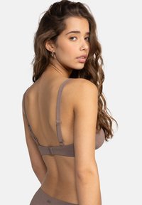Brown textured bra with adjustable straps and hook closure. Features a smooth design and minimalistic style without embellishments.