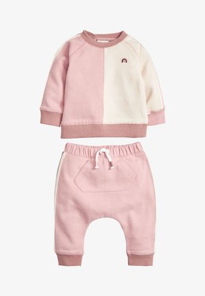 Sweat-shirt à manches longues bicolore rose et crème pour tout-petit, avec un petit arc-en-ciel brodé, et pantalon assorti rose avec taille élastique et cordon de serrage.